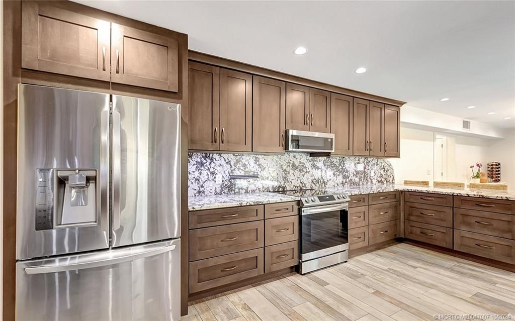 26 Rio Vista Drive Stuart, FL 34996 - Photo 22 of 58 a kitchen with stainless steel appliances granite countertop a refrigerator and a stove top oven