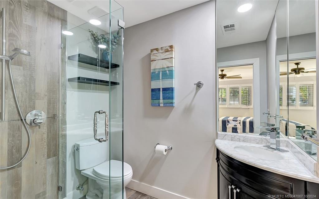 26 Rio Vista Drive Stuart, FL 34996 - Photo 26 of 58 a bathroom with a granite countertop sink toilet a mirror and shower
