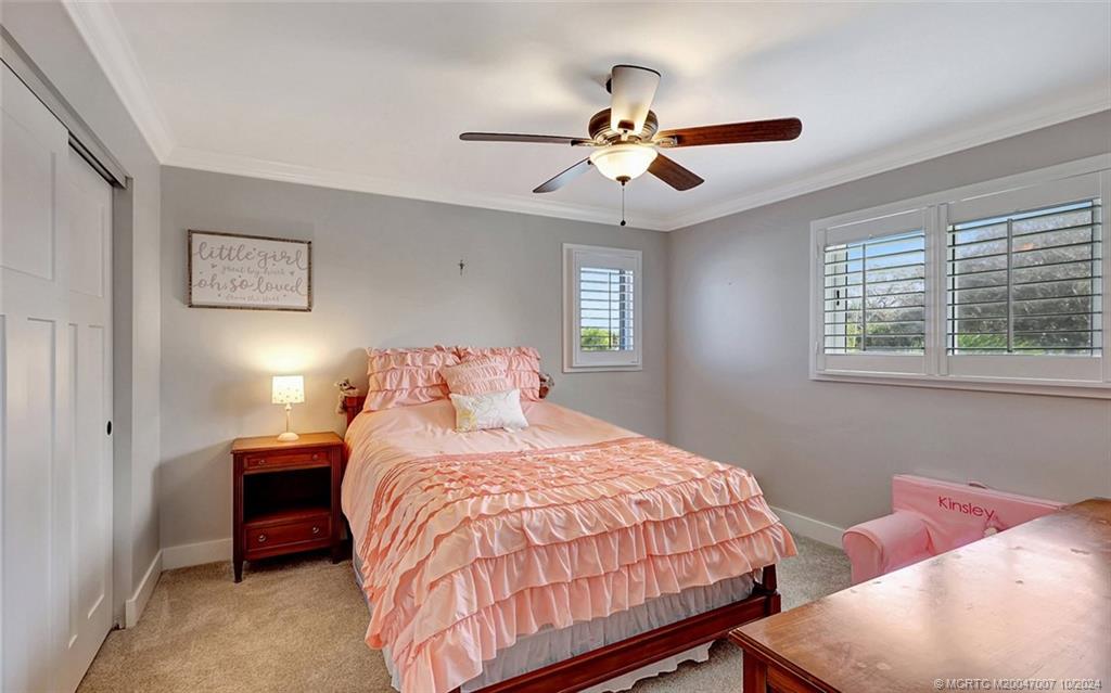26 Rio Vista Drive Stuart, FL 34996 - Photo 31 of 58 a bedroom with a bed and a chandelier