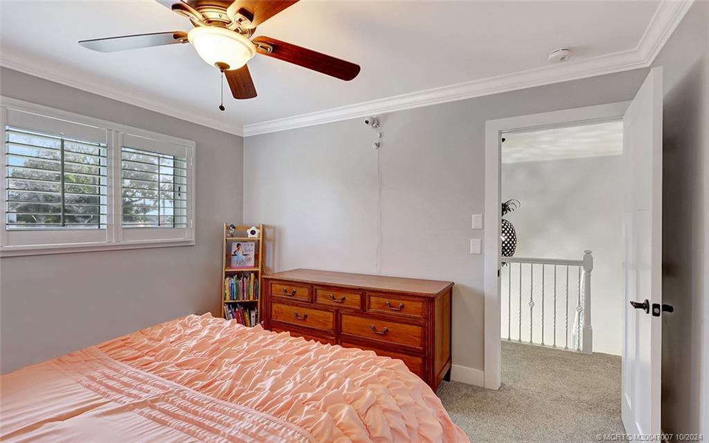 26 Rio Vista Drive Stuart, FL 34996 - Photo 32 of 58 a bedroom with a bed and a chandelier