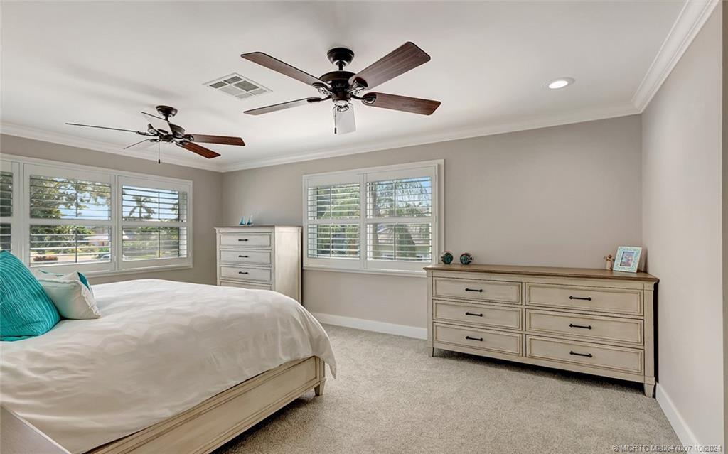 26 Rio Vista Drive Stuart, FL 34996 - Photo 38 of 58 a spacious bedroom with a large bed and a chandelier