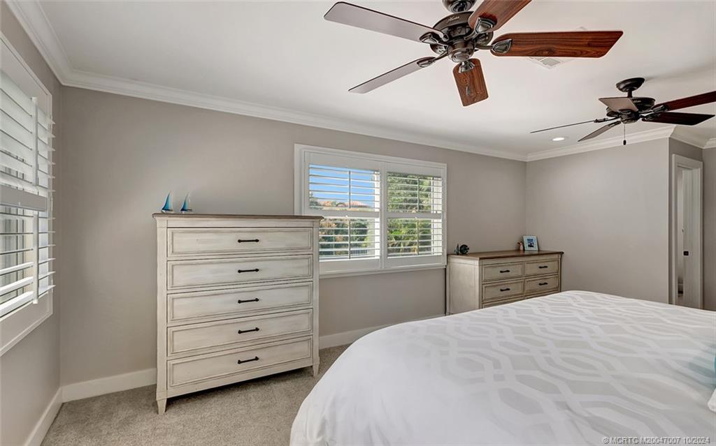 26 Rio Vista Drive Stuart, FL 34996 - Photo 41 of 58 a bedroom with a bed and a chandelier