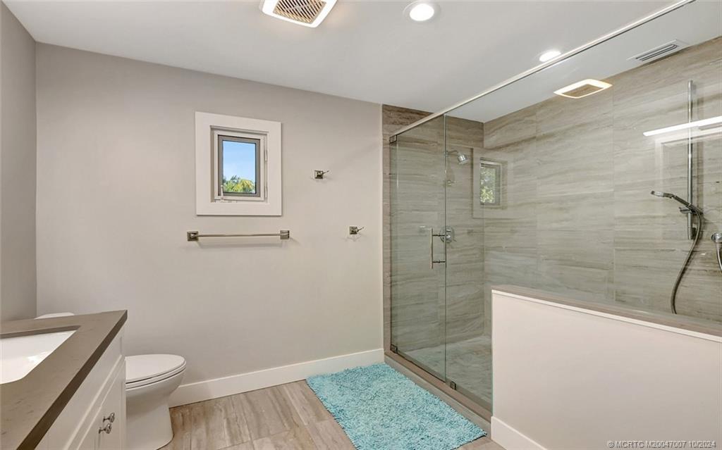 26 Rio Vista Drive Stuart, FL 34996 - Photo 45 of 58 a bathroom with a granite countertop sink a toilet and shower