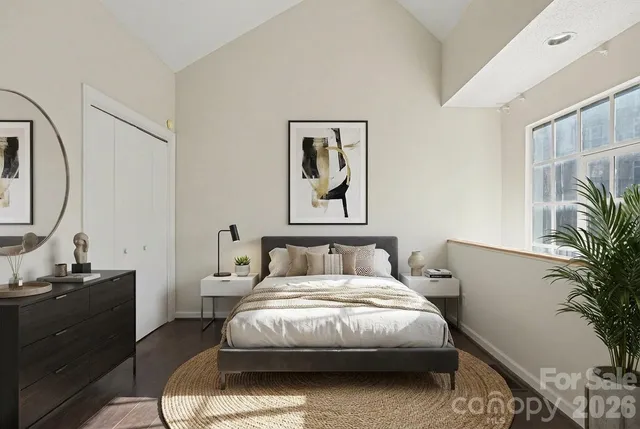 a bedroom with a bed and a potted plant on the dresser