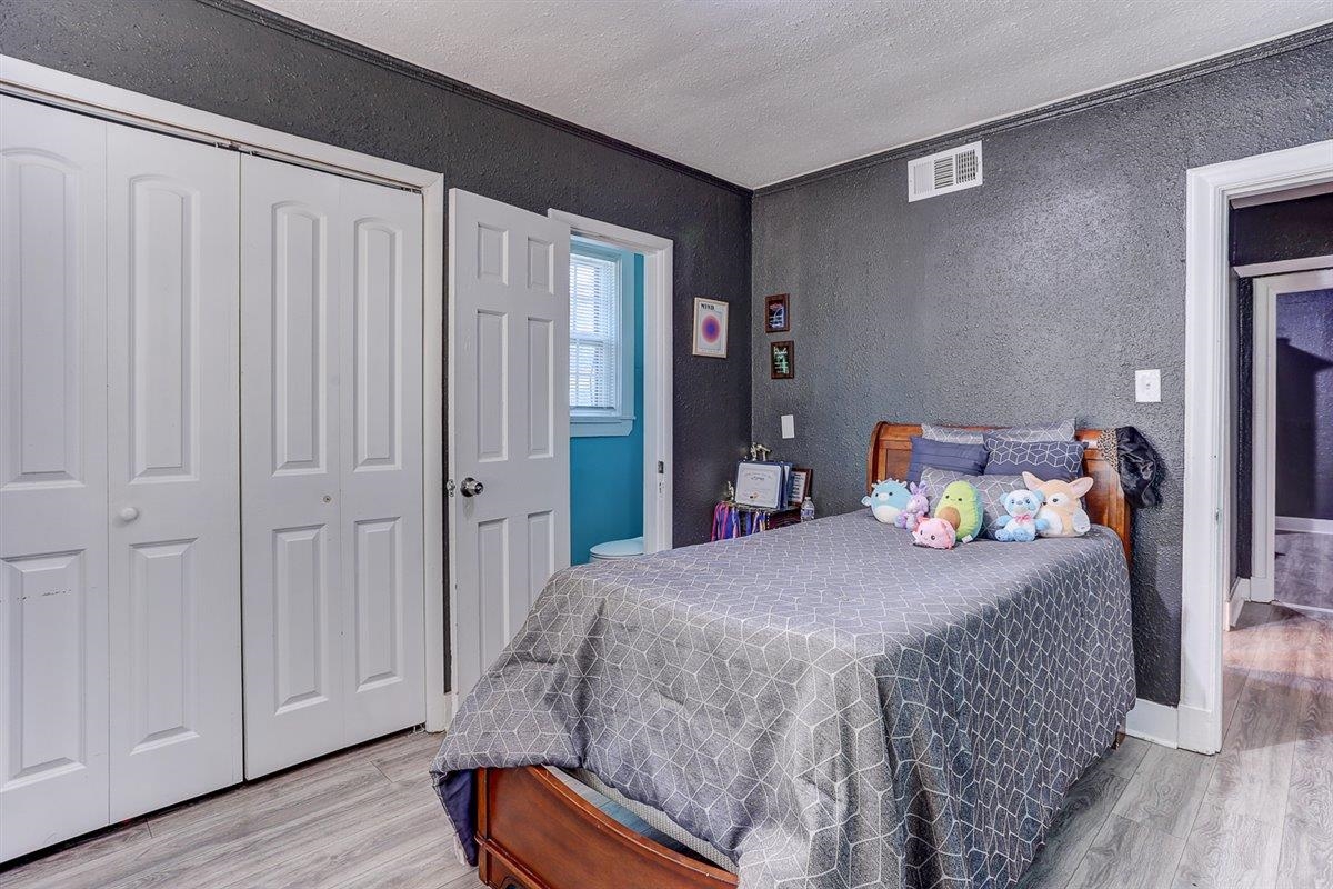 3700 Lakeview Road Memphis, TN 38116 - Photo 26 of 40 Bedroom with a closet, light wood-style flooring, a textured wall, and a textured ceiling