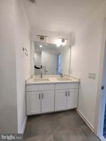a bathroom with a double vanity sink and a mirror