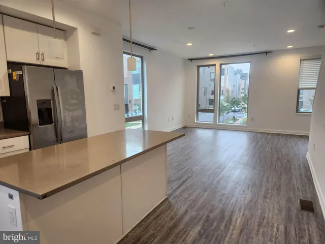 a kitchen with stainless steel appliances granite countertop a refrigerator a stove and a wooden floors