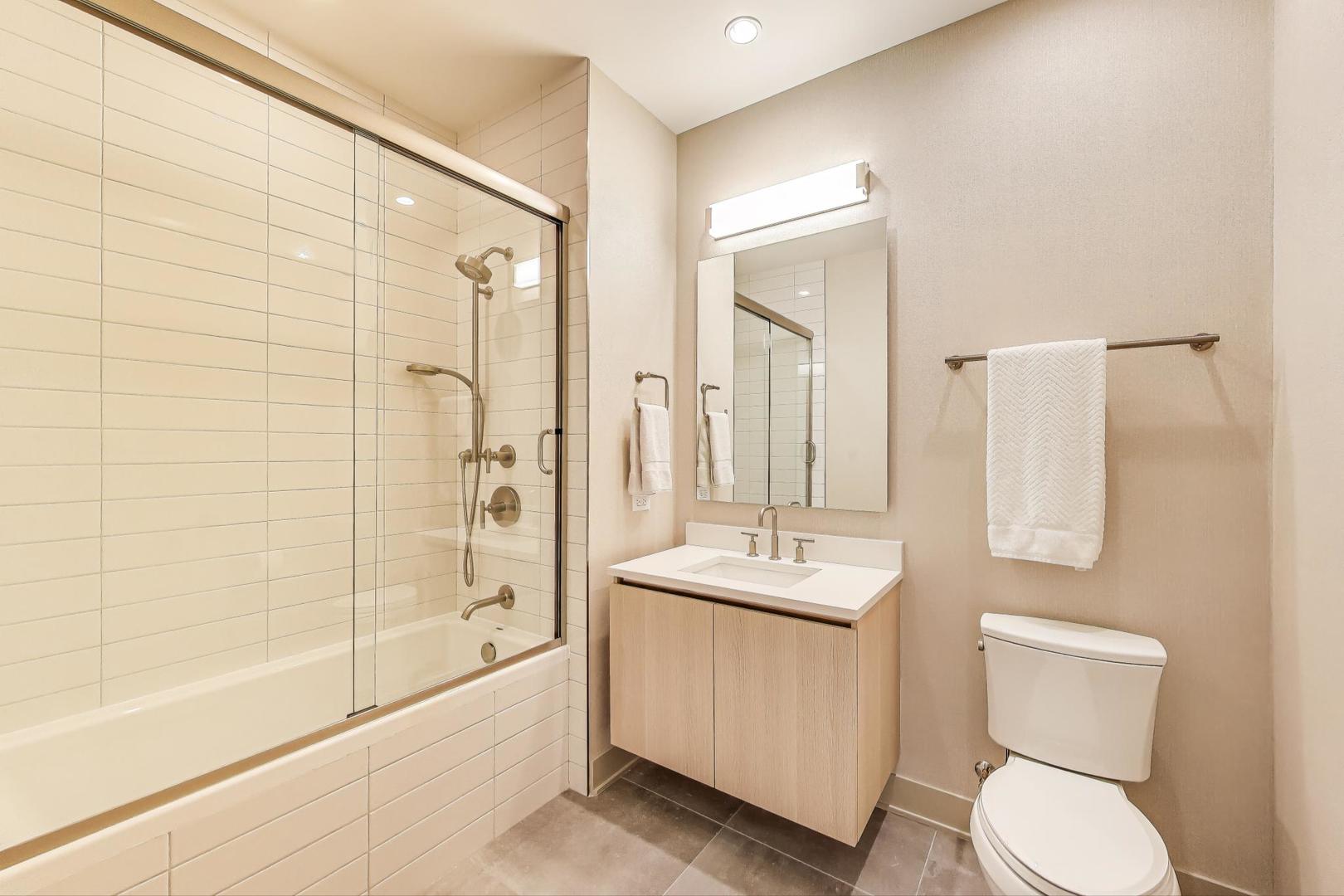 360 West Erie Street, Unit 7D Chicago, IL 60654 - Photo 24 of 39 a bathroom with a bathtub shower sink mirror and toilet