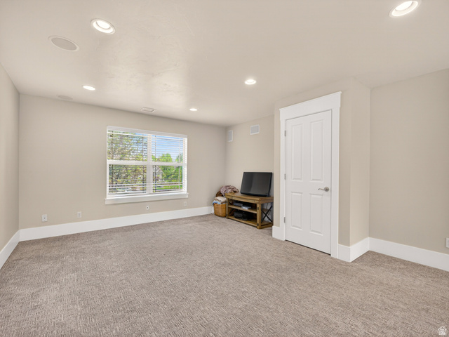 557 Craftsman Way Midway, UT 84049 - Photo 34 of 59 Recessed lighting illuminates this carpeted room featuring a double-paned window with blinds, a solid white door, and white baseboards