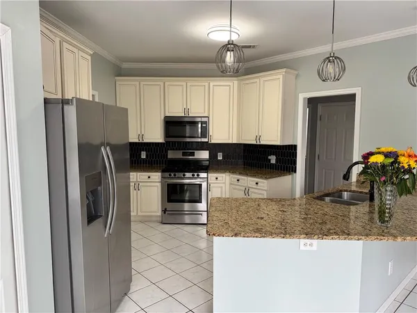 a kitchen with granite countertop white cabinets and appliances