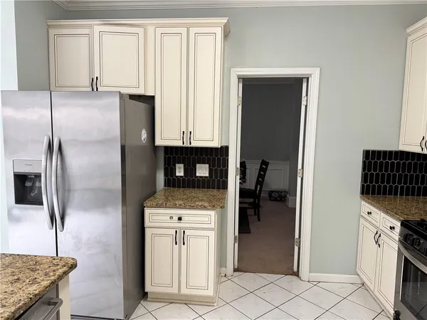 a kitchen with granite countertop a refrigerator and a sink