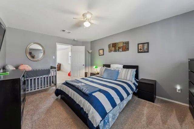a spacious bedroom with a bed and a chandelier