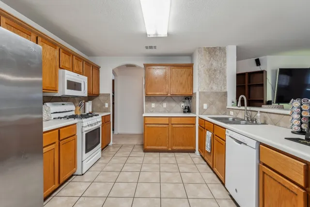 a large kitchen with stainless steel appliances granite countertop a sink and cabinets