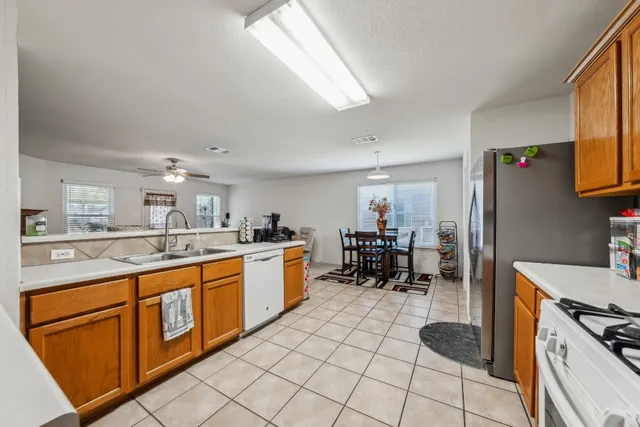 a kitchen with stainless steel appliances granite countertop a stove a sink and a refrigerator