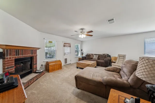 a living room with furniture a fireplace and a flat screen tv