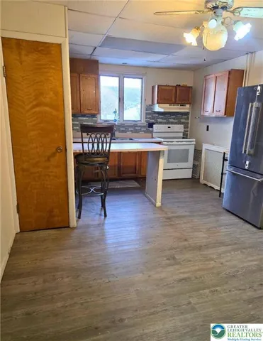 a view of kitchen with granite countertop a stove and a wooden floors