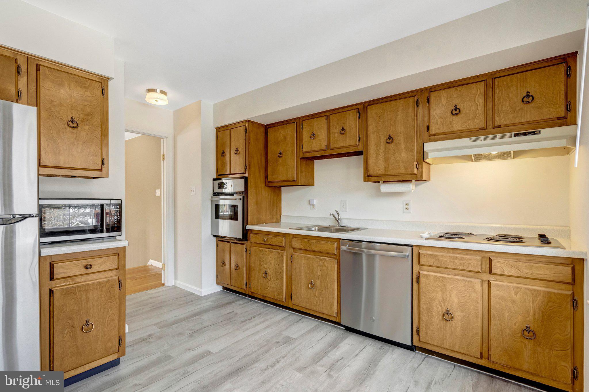 7413 Forrester Lane Manassas, VA 20109 - Photo 8 of 45 a kitchen with cabinets wooden floor and stainless steel appliances