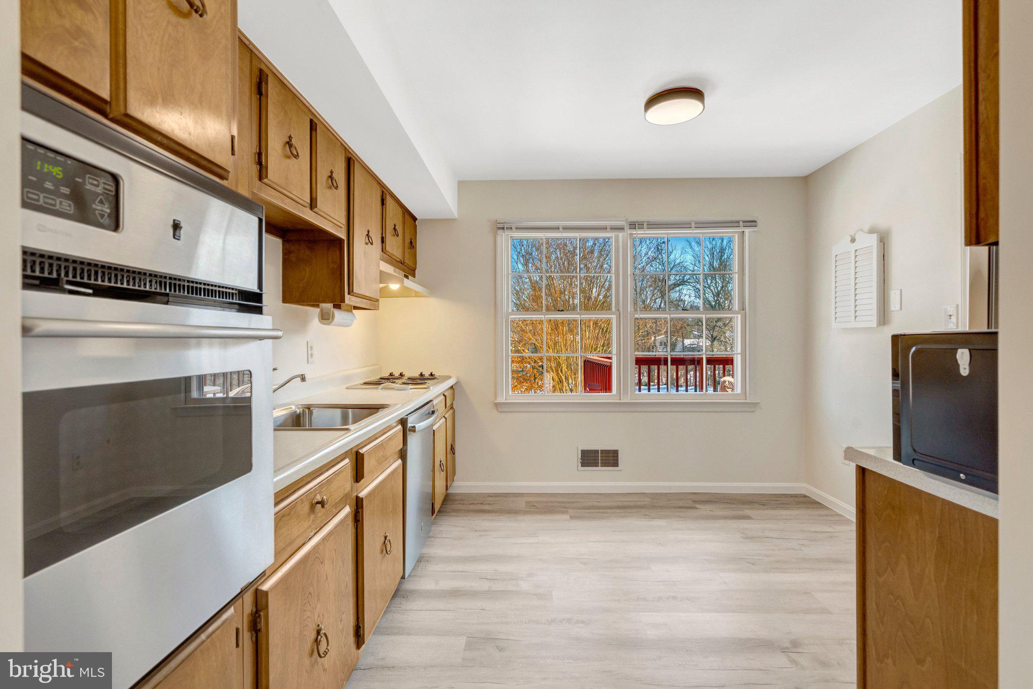 7413 Forrester Lane Manassas, VA 20109 - Photo 9 of 45 a kitchen with stainless steel appliances a stove microwave and a refrigerator