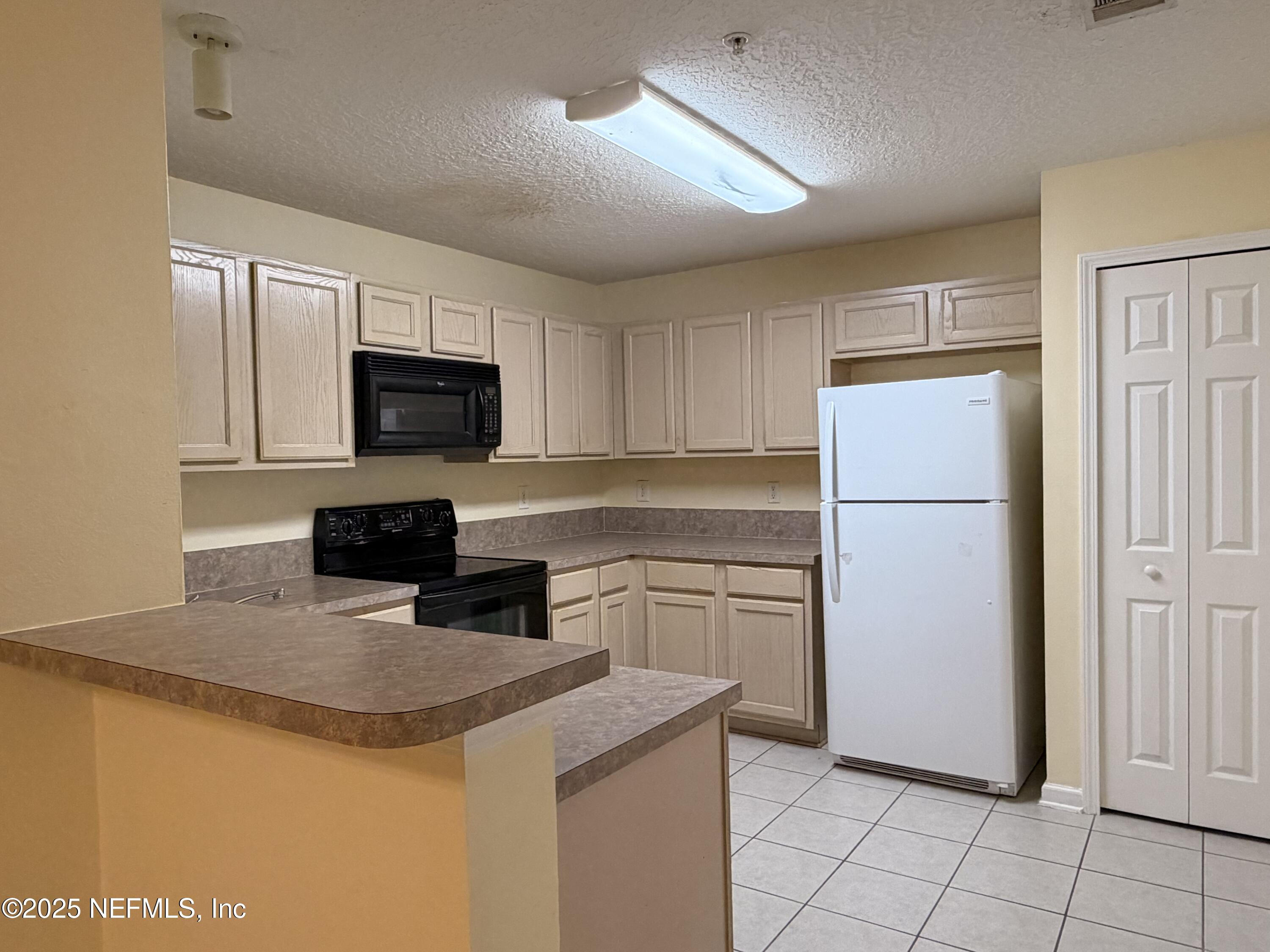 7920 Merrill Road, Unit 810 Jacksonville, FL 32277 - Photo 7 of 14 a kitchen with a refrigerator sink and microwave