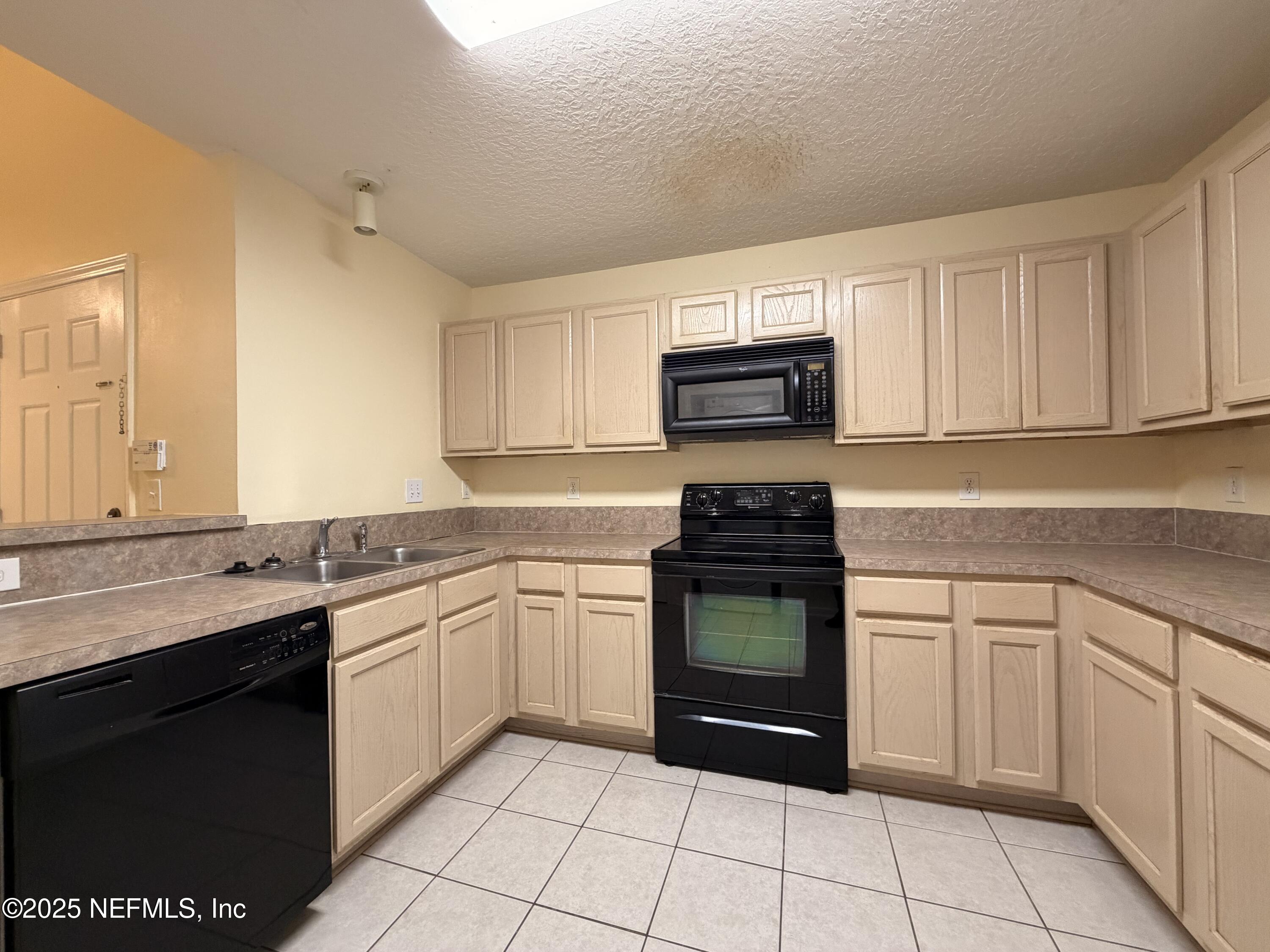 7920 Merrill Road, Unit 810 Jacksonville, FL 32277 - Photo 8 of 14 a kitchen with a sink stove and microwave