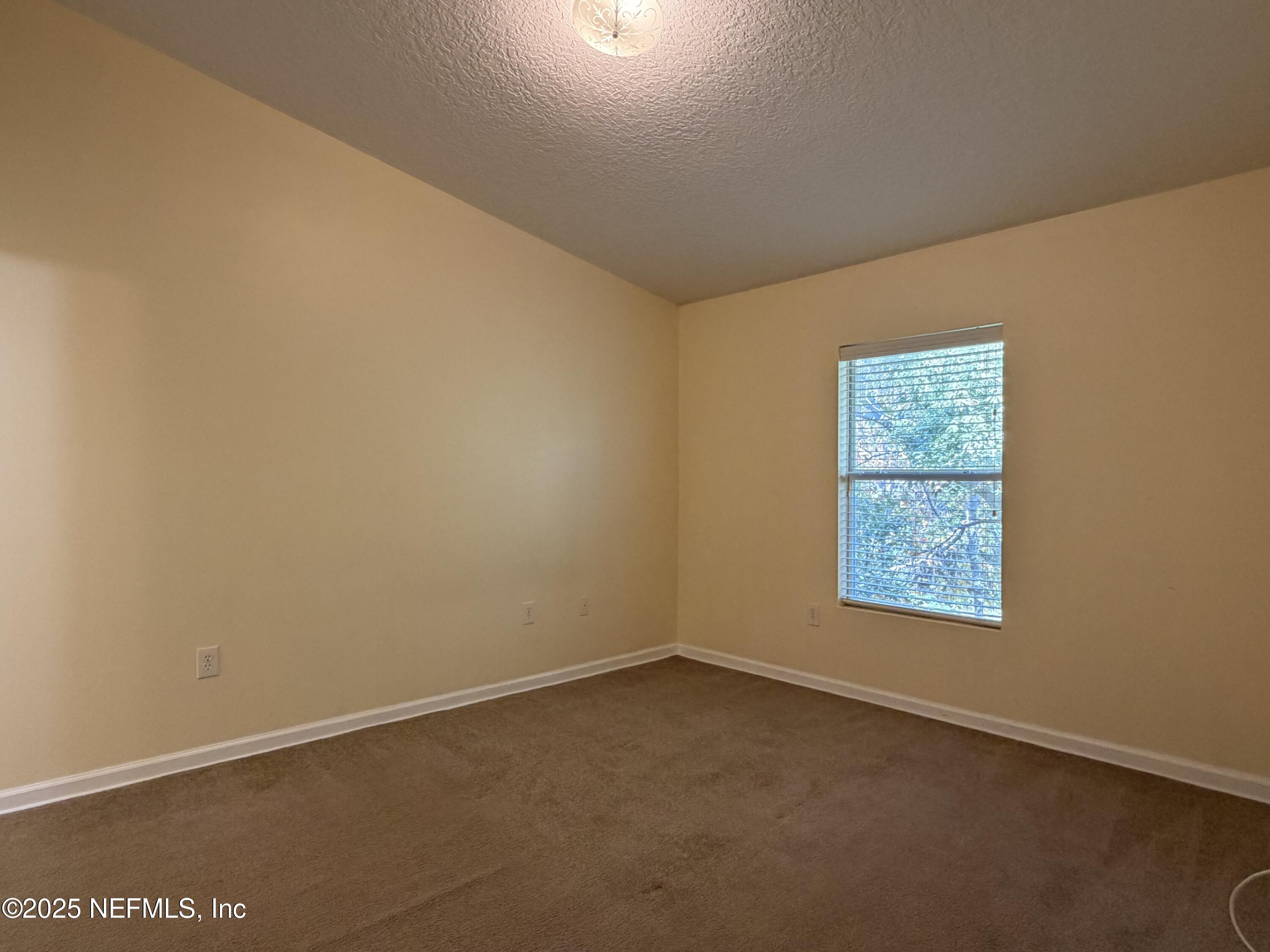 7920 Merrill Road, Unit 810 Jacksonville, FL 32277 - Photo 9 of 14 an empty room with a window