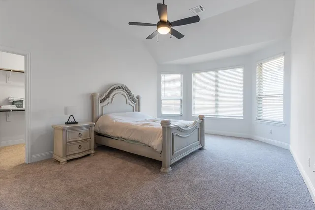 a spacious bedroom with a bed and a large window