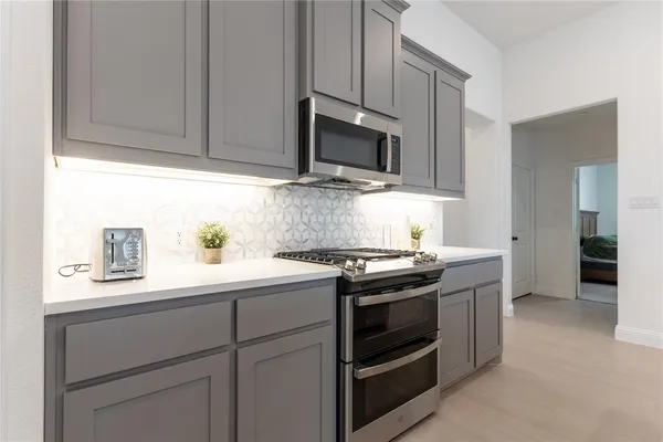 a kitchen with stainless steel appliances granite countertop a sink stove and microwave