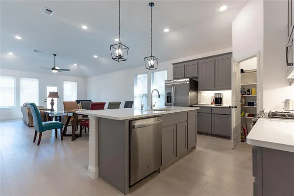 a large kitchen with kitchen island a sink a counter space and stainless steel appliances