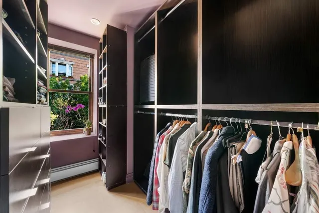 a view of walk in closet with clothes and shoes