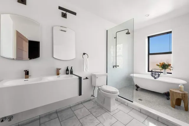 a bathroom with a bathtub sink mirror and toilet