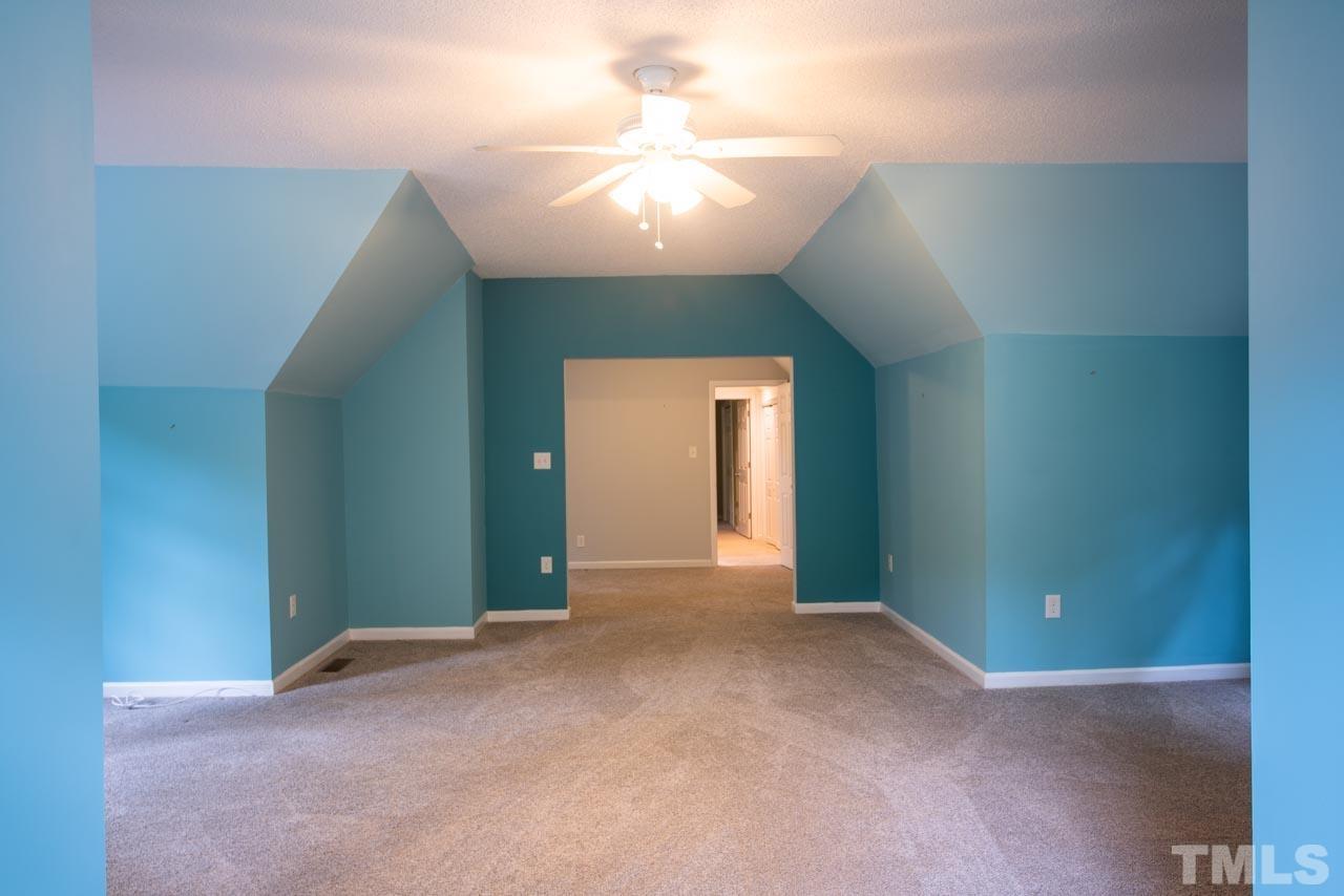 116 Baldwin Drive Durham, NC 27712 - Photo 22 of 33 an empty room with a chandelier fan and windows