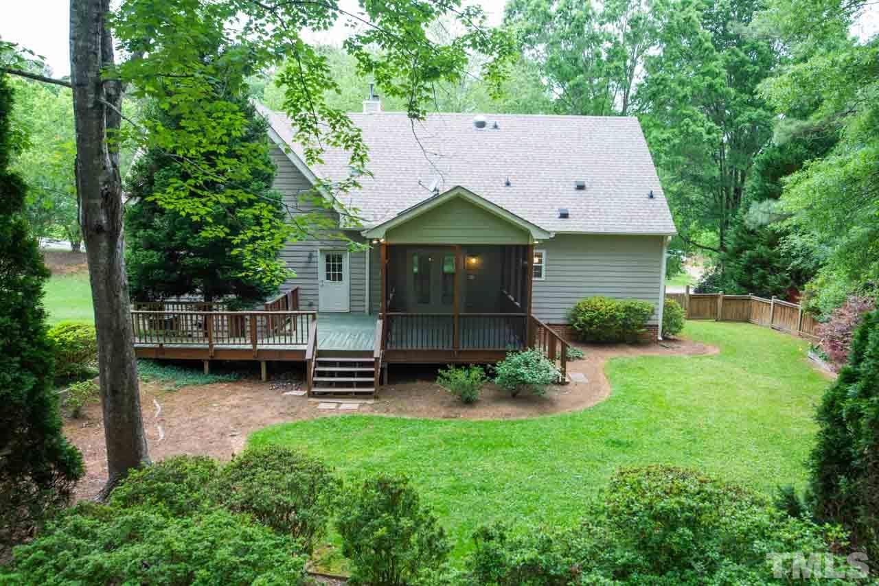 116 Baldwin Drive Durham, NC 27712 - Photo 30 of 33 a backyard of a house with table and chairs a barbeque with potted plants and a large tree