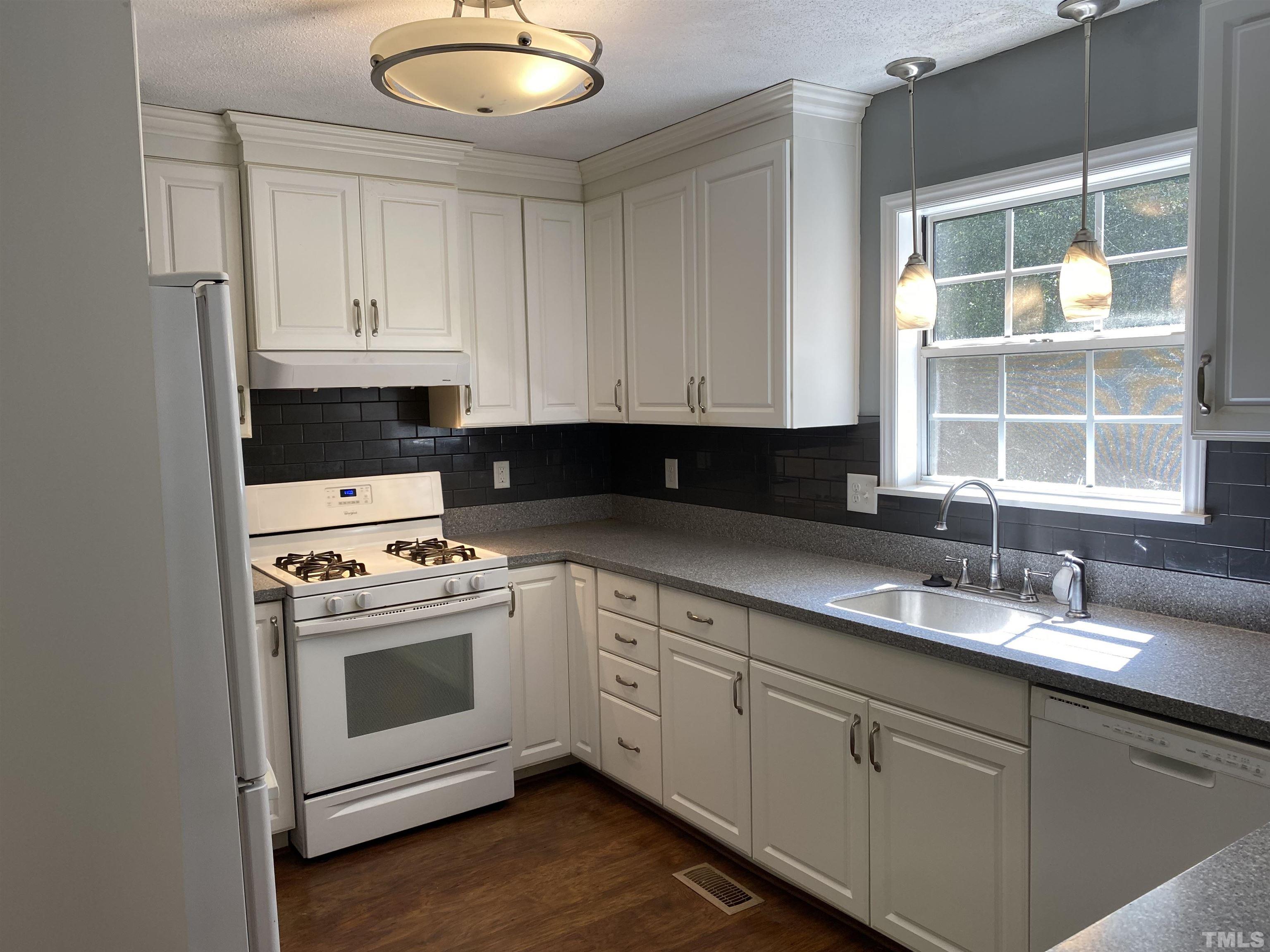 116 Baldwin Drive Durham, NC 27712 - Photo 3 of 33 a kitchen with granite countertop white cabinets and white appliances