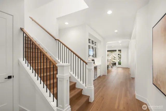 a view of a hallway with wooden floor and staircase