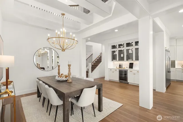 a view of a dining room with furniture a chandelier and wooden floor