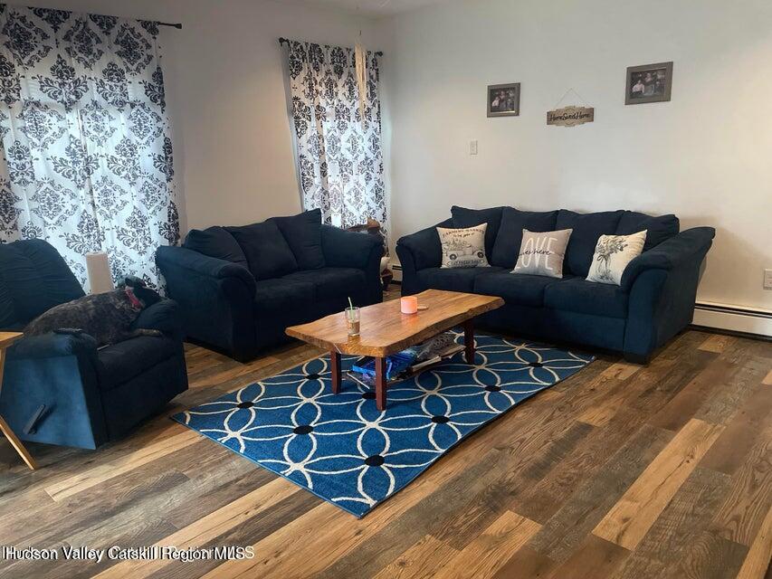 119 Baker Road Kerhonkson, NY 12446 - Photo 14 of 15 a living room with furniture a dining table and chairs with wooden floor