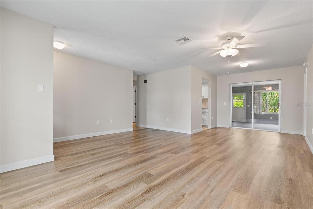 11241 Rollingwood Drive Port Richey, FL 34668 - Photo 14 of 26 a view of an empty room with window and wooden floor