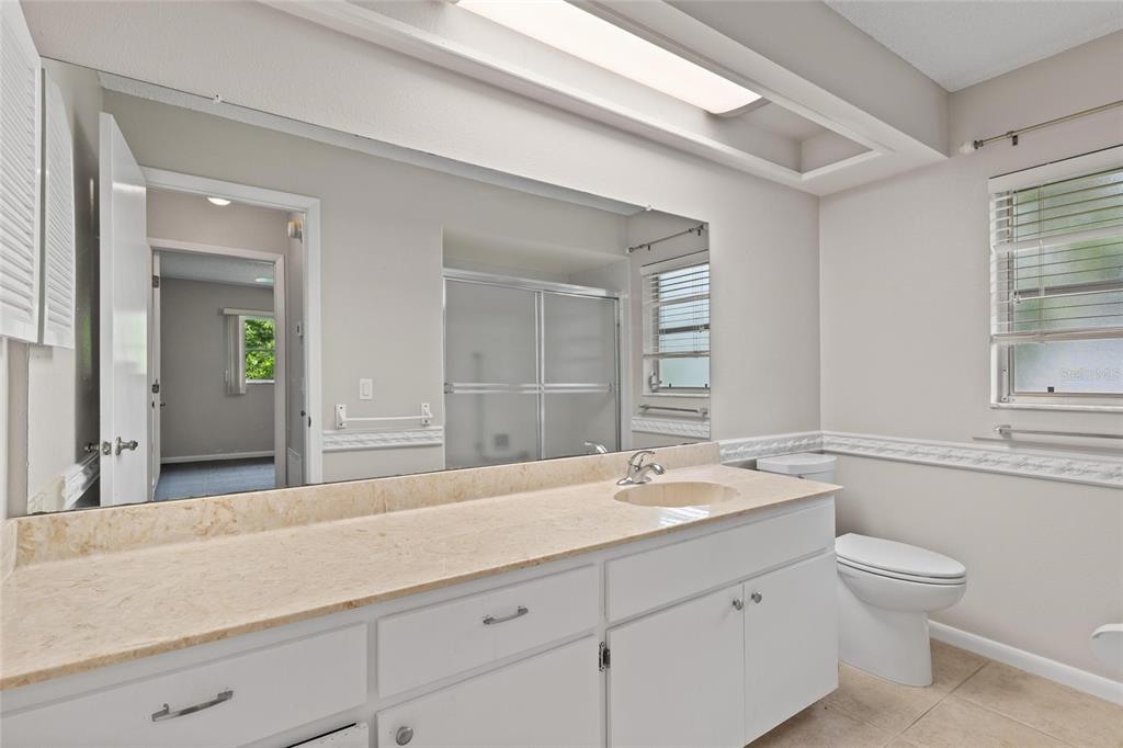 11241 Rollingwood Drive Port Richey, FL 34668 - Photo 19 of 26 a bathroom with a sink a toilet and a mirror