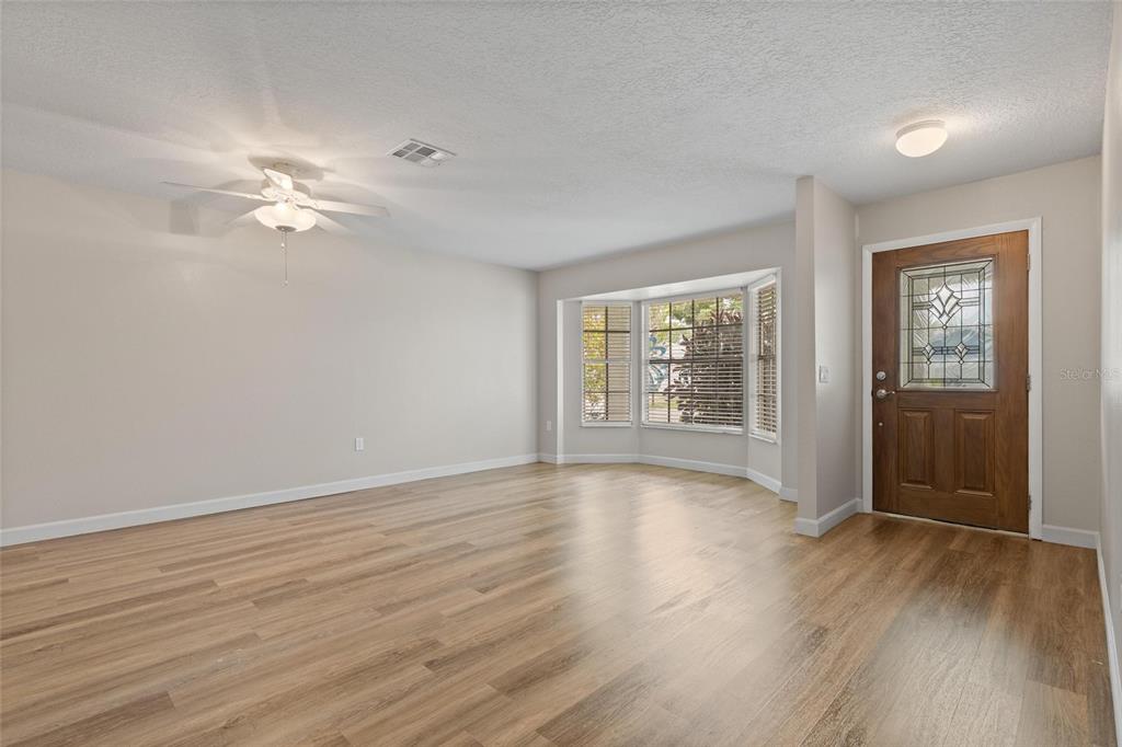 11241 Rollingwood Drive Port Richey, FL 34668 - Photo 4 of 26 wooden floor in an empty room with a window