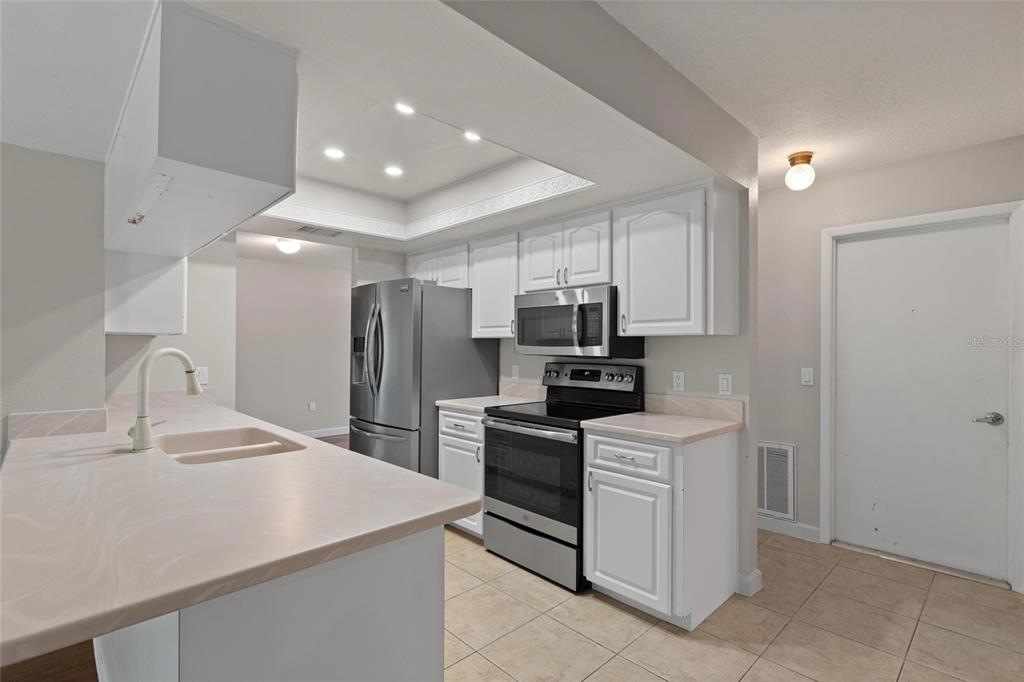 11241 Rollingwood Drive Port Richey, FL 34668 - Photo 10 of 26 a kitchen with a sink stainless steel appliances and white cabinets