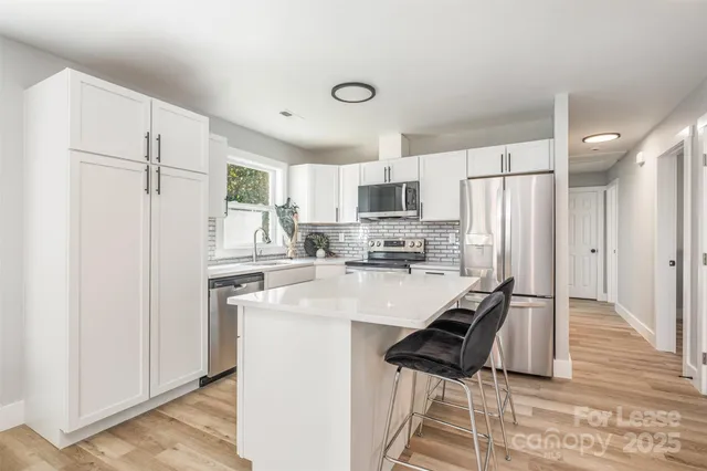 a kitchen with kitchen island a refrigerator stove and sink
