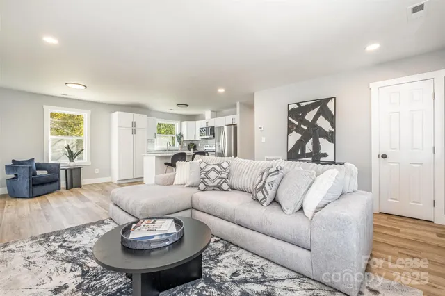 a living room with furniture and a wooden floor