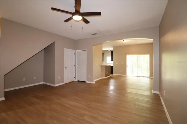 a view of an empty room with window and wooden floor