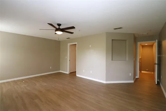 a view of an empty room with wooden floor