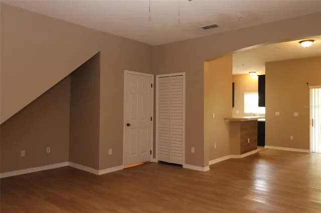 an empty room with wooden floor and windows