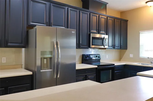 a kitchen with stainless steel appliances granite countertop a refrigerator and a sink