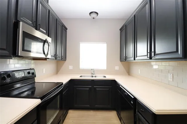 a kitchen with stainless steel appliances a sink stove and microwave