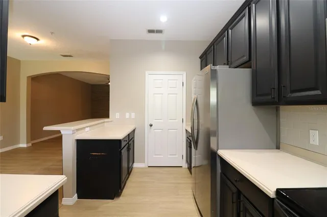a kitchen with stainless steel appliances granite countertop a refrigerator and a sink