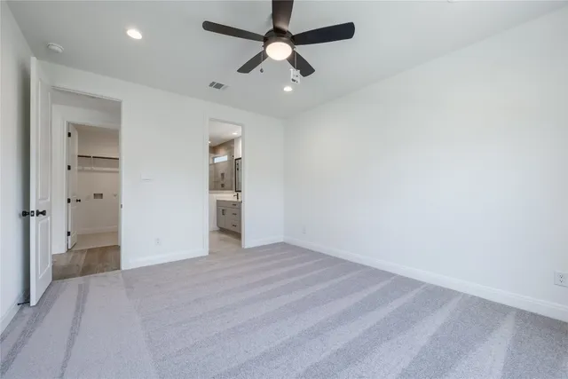 an empty room with closet and a ceiling fan