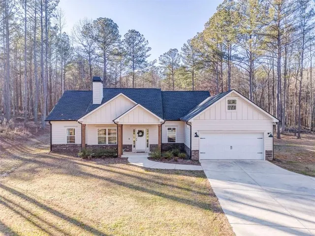 a view of a house next to a yard with large tree